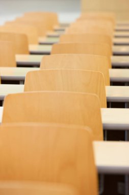 Ahşap masalar ve sandalyelerle dolu boş bir sınıf.  