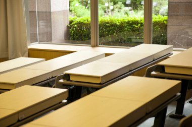 boş sınıf içi ahşap masalarla dolu.