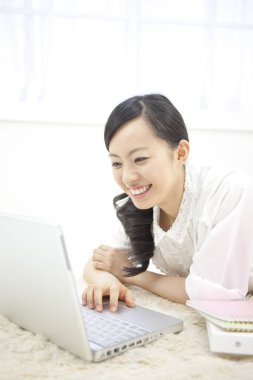 Evde dizüstü bilgisayarı olan genç bir kadın. 