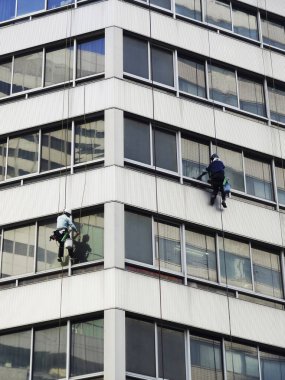 İşçiler pencereleri temizlemek için gökdelene tırmanıyorlar. 