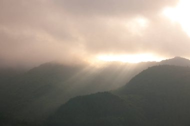 Güneşin doğuşundaki sisli dağların güzel manzarası