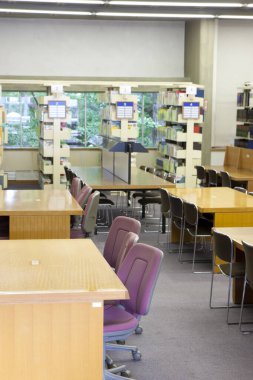 Üniversite kütüphanesinin içi kitaplık ve diğer mobilyalarla dolu
