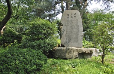 Parkta Çince sembolleri olan anıt taşının manzarası