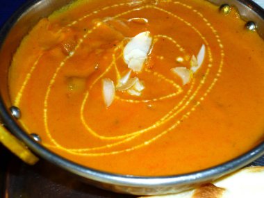 Bademle süslenmiş kremalı turuncu köri.