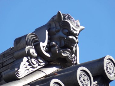 Geleneksel iblis yüzü oyması içeren süslü Japon çatı fayansları.