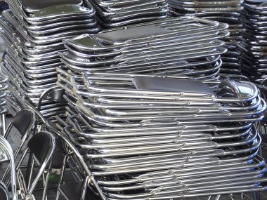 Depolama alanında ışığı yansıtan metal sandalyeler