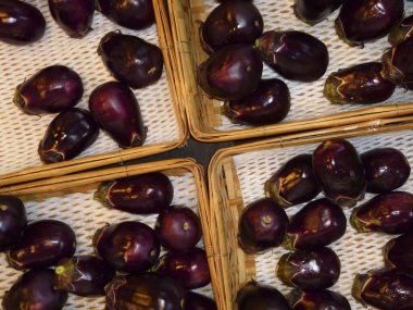 Hasır sepetlere yerleştirilmiş mor patlıcanlar.