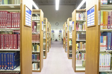 Üniversite kütüphanesinin içi kitaplık ve diğer mobilyalarla dolu