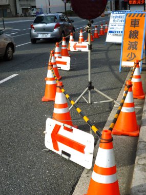 Şehirdeki trafik konilerinin yanından geçen arabalar