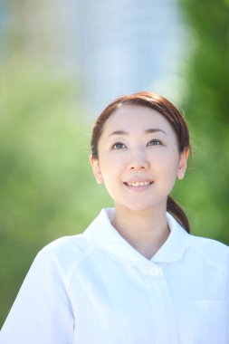 Parka bakan genç bir hemşirenin portresi. 