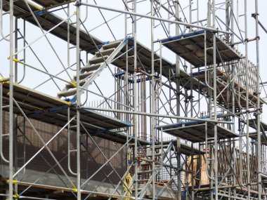 Şehirdeki inşaat alanında metal iskeleler var. 