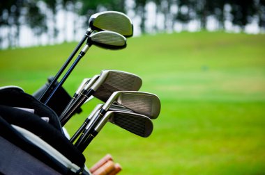 Golf sahasının çimenli çimlerinde golf sopalarıyla çantasını kapat.