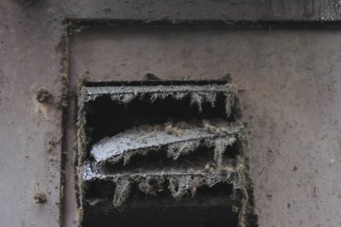 Kalın örümcek ağlarıyla kaplı tozlu hava menfezi