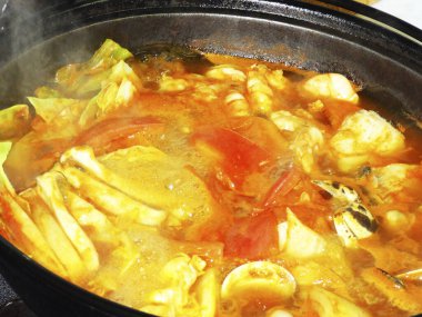 Buharlı deniz ürünleri güveci ve tencerede sebze.