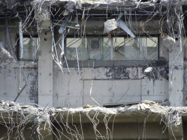 Yıkılan beton bina, açıkta duran demiri ve kırık camları gösteriyor