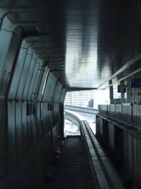 Metalik duvarlar ve rayların yer aldığı boş gelecekçi tren istasyonu platformu