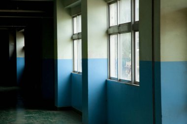 Mavi duvarları ve pencereleri olan boş koridor