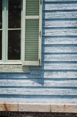 Dışarıdaki yeşil pencerenin altında eskimiş mavi ahşap kaplama.
