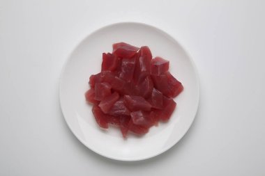 Beyaz tabakta doğranmış çiğ ton balığı.