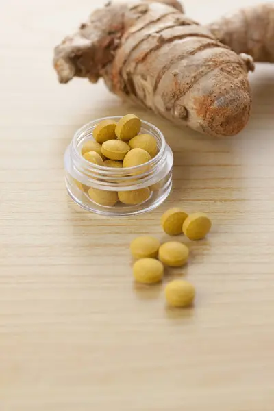 turmeric root capsules or pills on white background close up
