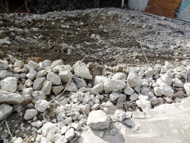 İnşaat alanının zemin yüzeyine dağılmış taşlar ve kir.