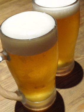 Tahta masadaki soğuk bira bardaklarının yakın plan görüntüsü.      