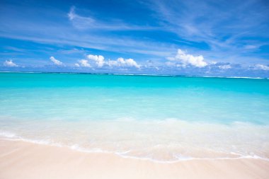 Tropikal tatil beldesindeki kumlu kumsal manzarası.