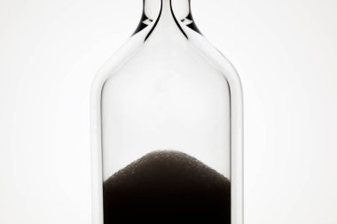 Beyaz arkaplanda kum bulunan kum saatinin yakın görüntüsü     