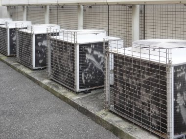 Beton duvar boyunca eski açık hava havalandırma üniteleri.