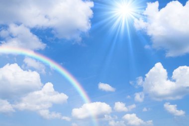 Gökkuşağı beyaz bulutlu mavi bir gökyüzünde