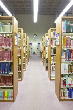 Üniversite kütüphanesinin içi kitaplık ve diğer mobilyalarla dolu