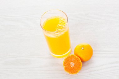 Bardakta sağlıklı meyve suyu ve taze mandalina.