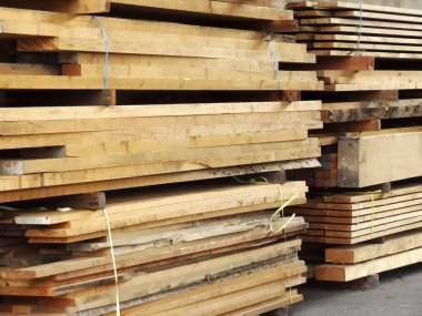 Doğal güneş ışığı altında istiflenmiş ahşap tahtalar.