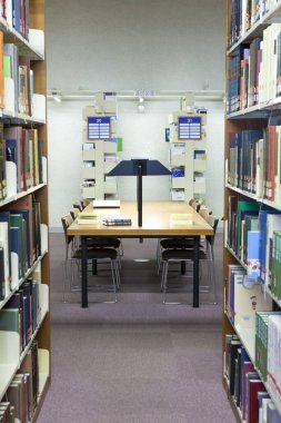 Üniversite kütüphanesinin içi kitaplık ve diğer mobilyalarla dolu