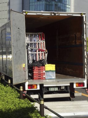 İçinde metal sandalyeler ve plastik sandıklar olan açık teslimat kamyonu