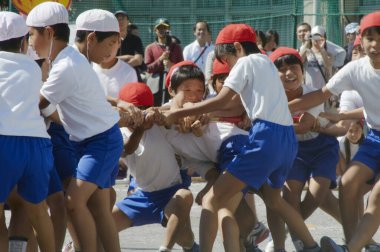 Okul bahçesinde aktif spor müsabakası olan üniformalı Asyalı çocuklar 
