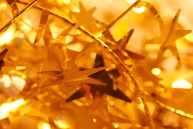 Noel arkaplanı, altın yıldızlar ve parlak ışıklar.