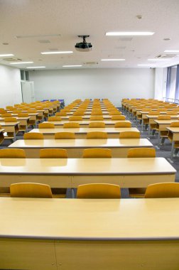 Okulda tahta sandalyeleri ve masaları olan boş bir sınıf.