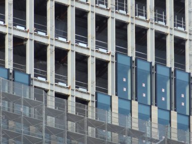 Açığa çıkan beton sütunların yer aldığı modern bina