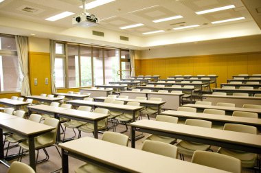 Sandalyeleri ve masaları olan boş konferans salonunun içi