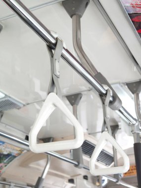 Otobüsün içindeki metal direklerden sarkan beyaz kollar.