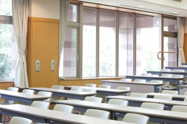 Masaları ve sandalyeleri olan boş modern sınıf 