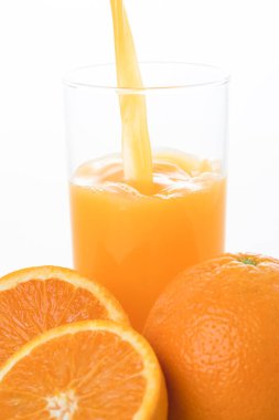 Bardakta sağlıklı portakal suyu ve taze portakal.