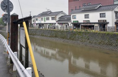 Sakin nehir suyunda yansıyan geleneksel Japon binaları
