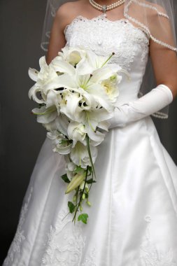 Gelin elinde bir buket çiçek tutuyor.