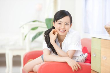 gülümseyen genç kadın evde rahatlatıcı