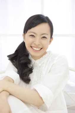 Zarif Japon kadın, temiz, parlak beyaz bir ortamda güven içinde poz veriyor.. 