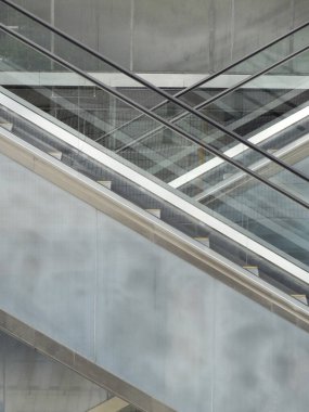 Beton binada aşağı doğru ilerleyen modern yürüyen merdiven