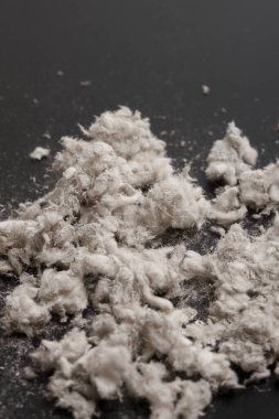 Siyah arkaplanda beyaz pamuk parçaları yığını, yakın çekim 