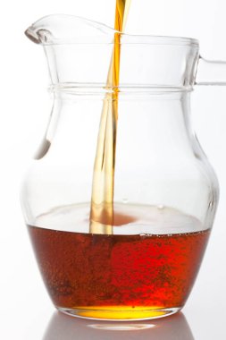 beyaz arkaplanda izole edilmiş sürahiye sıvı dökülüyor 